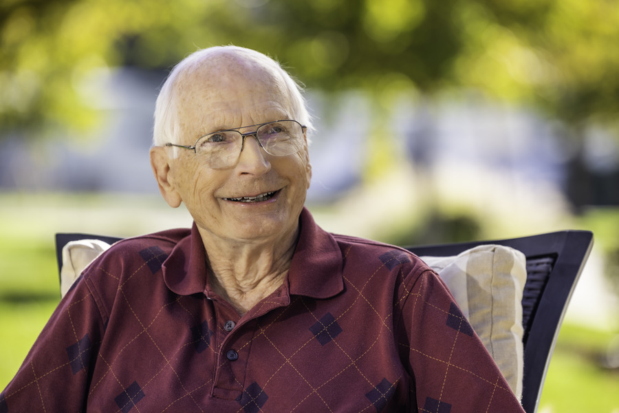 man smiling while seated outside